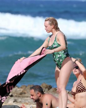 Jorgie porter in a green patterned swimsuit at beach